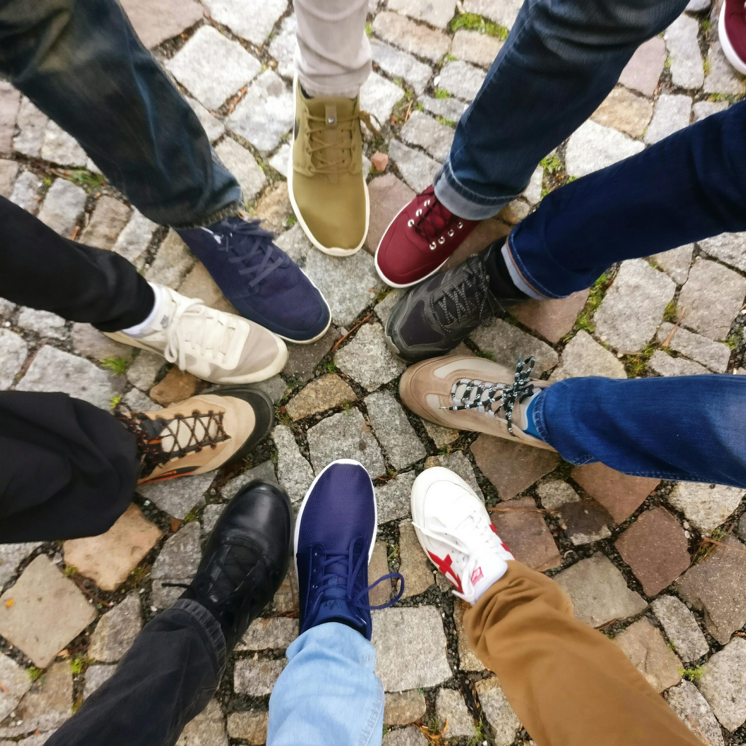 SEFNET Circle of sneakers on cobblestone pavement representing diversity and urban fashion.